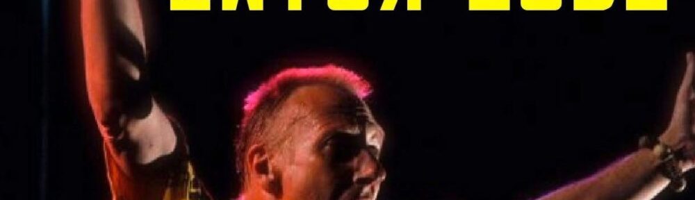 A picture of someone singing into a microphone with arms raised. Stylised text saying 'Owter Zeds' is above them.